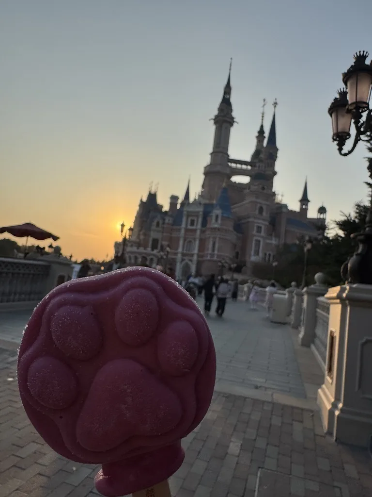 夕暮れのお城を背景にした肉球型のアイスキャンディー